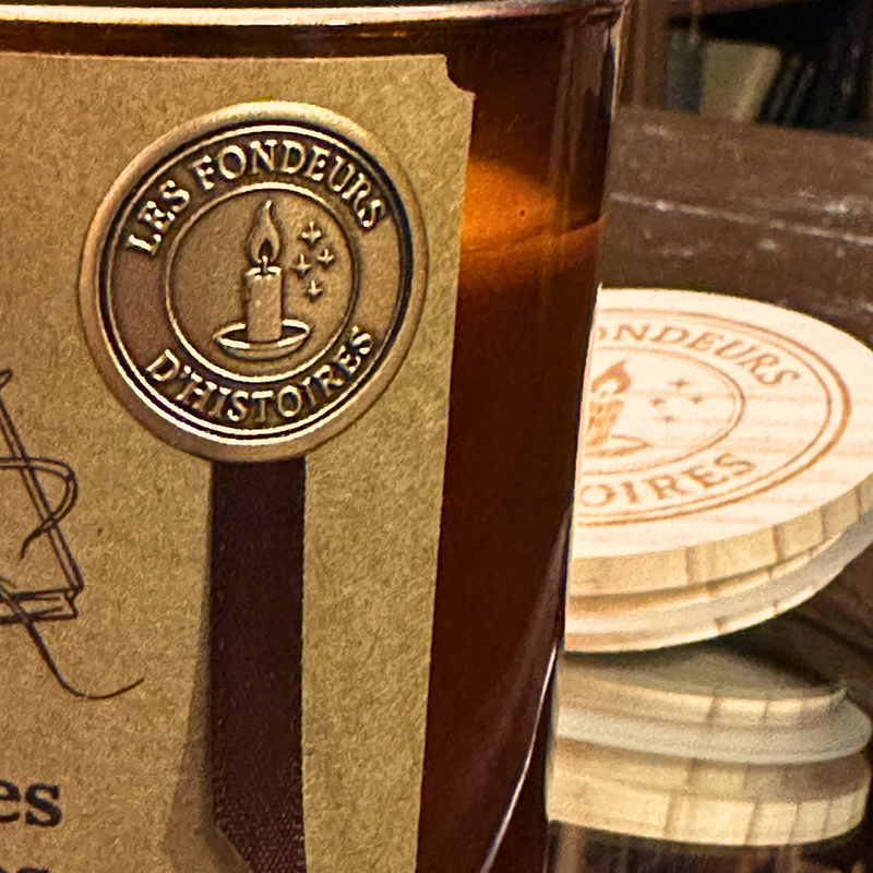 Gold seal applied by hand on the label of a Les Fondeurs d'Histoires candle